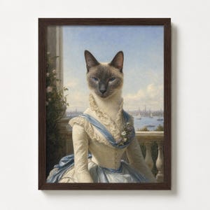 May include: Framed artwork featuring a Siamese cat in a vintage dress, set against a scenic backdrop. The cat is the focal point, wearing a cream-colored dress with blue accents. The background shows a cityscape and water, framed in a dark brown wooden frame.