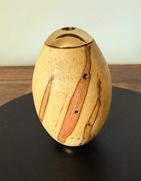 A hand-turned kaleidoscope made from stunning Box Elder wood — each one is a one-of-a-kind optical toy you can actually hold and twist.