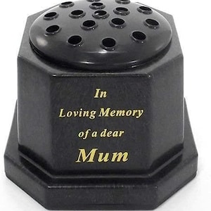 Puede incluir: Jarrón de cerámica octogonal negro con parte superior redonda y múltiples agujeros para flores. El jarrón tiene la inscripción "In Loving Memory of a dear Mum".
