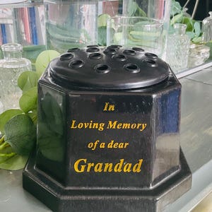 Puede incluir: Jarrón de flores octogonal negro con letras doradas que dicen "In Loving Memory of a dear Grandad".