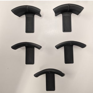 Op de afbeelding: Vijf zwarte kunststof wandbeugels in de vorm van een gebogen beugel. De beugels zijn ontworpen om items zoals koptelefoons of snoeren te houden.