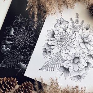 May include: Two black and white illustrations of floral arrangements with butterflies and ferns. The illustrations are on white paper and are framed by a black background. The illustrations are surrounded by dried grasses.