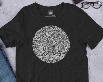 May include: A dark heather grey t-shirt with a circular design of a stylized flower in a light grey color. The design is intricate and detailed, resembling a mandala.