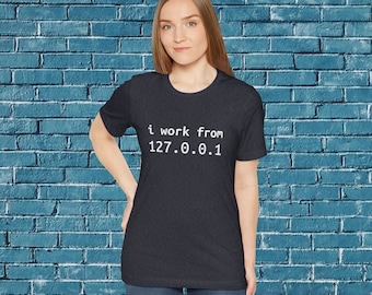 Op de afbeelding: Een donkergrijs t-shirt met de tekst "i work from 127.0.0.1" in wit.