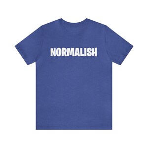 以下が含まれることがあります： ロイヤルブルーのTシャツで、前面に白い文字で「NORMALISH」と印刷されています。