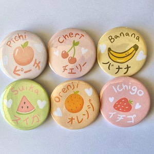 May include: Six circular pin badges with fruit designs. Each badge displays a different fruit: peach, cherry, banana, watermelon, orange, and strawberry. Each badge has the fruit's name in English and Japanese.