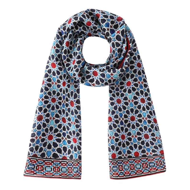 Large mulberry-silk scarf with Islamic geometry and Alhambra-inspired pattern, red border draped over a woman's shoulders.