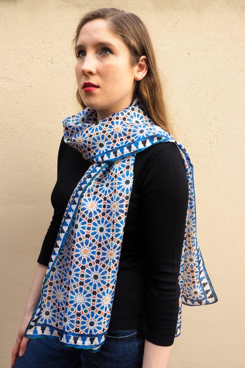 Moroccan tile-inspired silk scarf with blue, white, and orange geometric motifs; large women's neck scarf worn as a wrap.