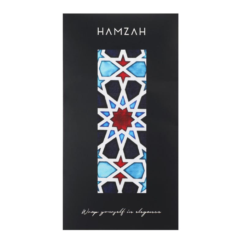 Large mulberry-silk scarf with Islamic geometry and Alhambra-inspired pattern, red border draped over a woman's shoulders.