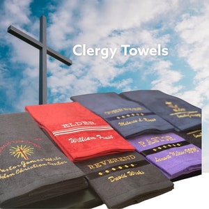 May include: A set of five clergy towels with embroidered titles, including "Elder", "Reverend", "Pastor", and "Other Stuff". The towels are in various colors, including red, gray, blue, and purple. The towels are stacked on top of each other, with the top towel being the "Elder" towel.