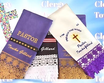 May include: Three embroidered towels with gold and purple lace trim. The towels are white, purple, and black. The white towel has a cross and the text "2 Tim Preach the Word Pastor Tonika Gillard". The purple towel has the text "Pastor Tonika Gillard". The black towel has the text "Gillard".