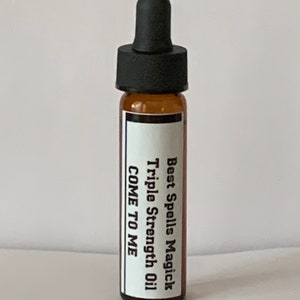 May include: A small brown glass bottle with a black dropper top. The bottle has a white label with the text "Best Spells Magick Triple Strength Oil COME TO ME".