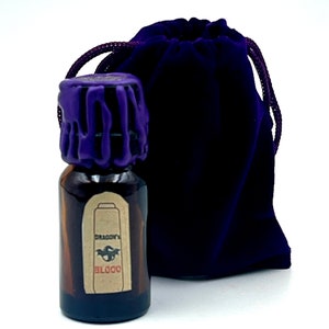 May include: A small brown glass bottle with a purple wax seal and a label that reads "Dragon's Blood". The bottle is in a small purple velvet bag.