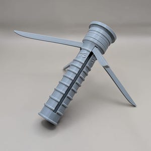 May include: A light gray plastic wall anchor with a ribbed body and expanding wings. The anchor is designed to be inserted into a pre-drilled hole and expand to secure screws. The wings provide additional grip.
