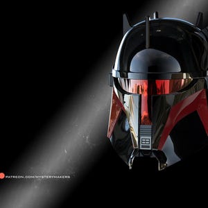 Peut inclure: Casque noir et rouge avec une visière réfléchissante, présentant un design épuré et des détails angulaires. Le casque a une finition brillante et est placé sur un fond sombre. L'image comprend le texte "PATREON.COM/MYSTERYMAKERS".