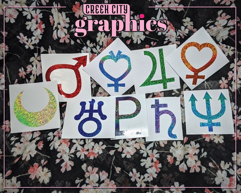 May include: Nine glitter stickers featuring various astrological symbols, including the moon, sun, Venus, Mars, Jupiter, Saturn, Uranus, Neptune, and Pluto. The stickers are on a white background and have a holographic finish.