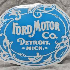 May include: A blue and white oval sticker with the text "Ford Motor Co. Detroit, Mich." surrounded by decorative flourishes.