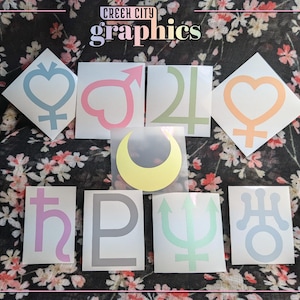 May include: Eight different colored vinyl stickers with astrological symbols. The symbols are: Venus, Mars, Jupiter, Saturn, Mercury, Uranus, Neptune, and Pluto. The stickers are on a floral background.