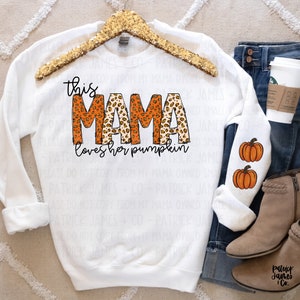 May include: White sweatshirt with the text "this mama loves her pumpkin" in orange and brown leopard print. The sleeves have a small orange pumpkin graphic.