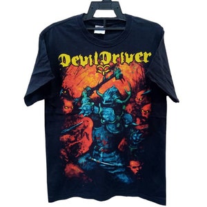 May include: Black t-shirt with a graphic print of a blue and red figure holding a sword. The text "DevilDriver" is printed in yellow on the shirt.