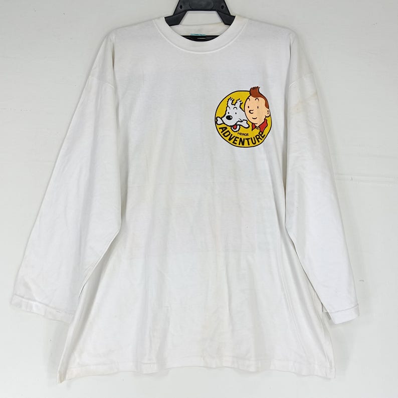 Puede incluir: Una taza de cer&aacute;mica blanca con un asa negra y el texto "But First, Coffee" en negrita negra. La taza est&aacute; sobre un fondo borroso. La taza mide aproximadamente 10 cm de altura.