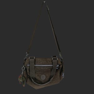 Könnte beinhalten: Eine braune Umhängetasche mit einem oberen Griff und einem abnehmbaren Schultergurt. Die Tasche hat eine Reißverschluss-Vordertasche und einen kleinen Affen-Schlüsselanhänger. Die Tasche besteht aus einem strukturierten Material und hat ein rundes Logo auf der Vorderseite.