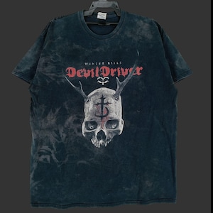 Puede incluir: Camiseta azul oscuro con un gráfico de calavera. La calavera tiene cuernos y un diseño de cruz. Los textos "WINTER KILLS" y "DevilDriver" son rojos. La camiseta tiene un aspecto descolorido y vintage.