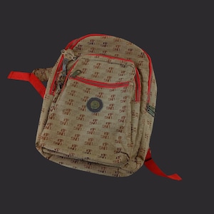 May include: Tan crossbody bag with red trim and straps. The bag features a repeating pattern of the text "KIP LING" in brown. It has a front pocket with a zipper and a small circular emblem.