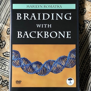 May include: A black DVD case with the title "Braiding with Backbone" in white text. The cover features a blue and gold DNA-like braid design. The author's name, Marilyn Romatka, is at the top. The DVD logo is visible.