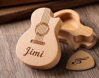 May include: A wooden guitar-shaped box with the name "Jimi" engraved on it. The box is open and has a smaller wooden box inside. There is also a wooden guitar pick with a treble clef engraved on it.