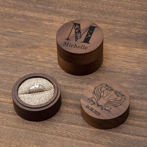 May include: Two wooden ring boxes. One box is engraved with the letter "M" and the name "Michelle". The other box is engraved with two horses' heads in a heart shape and the names "Mary" and "Paul" with the date "04.08.2023".