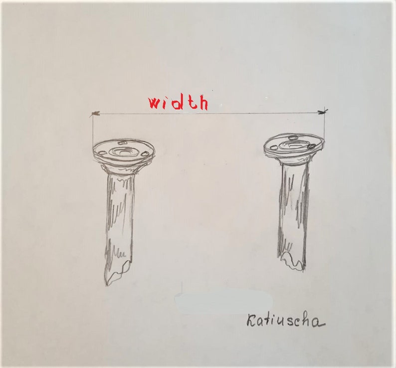 May include: A hand-drawn illustration of two gray columns with a flat top. The word "width" is written in red above the columns. The word "Katiuschka" is written in black at the bottom of the image.