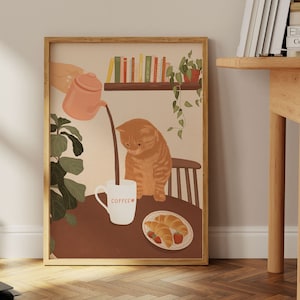 May include: A framed illustration of an orange cat sitting at a table with a mug that says "COFFEE" and a plate of croissants. A hand pours coffee from a pink teapot into the mug.