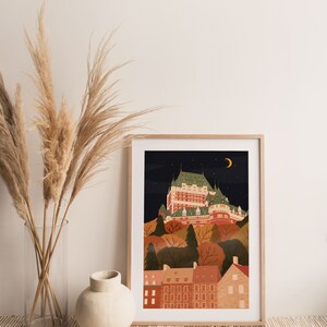 May include: A framed illustration of a cityscape at night with a large building in the center. The building is a light brown color with white trim and has many windows. The cityscape is surrounded by trees and houses. The sky is dark blue with stars and a crescent moon.