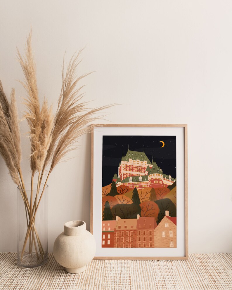 May include: A framed illustration of a cityscape at night with a large building in the center. The building is a light brown color with white trim and has many windows. The cityscape is surrounded by trees and houses. The sky is dark blue with stars and a crescent moon.