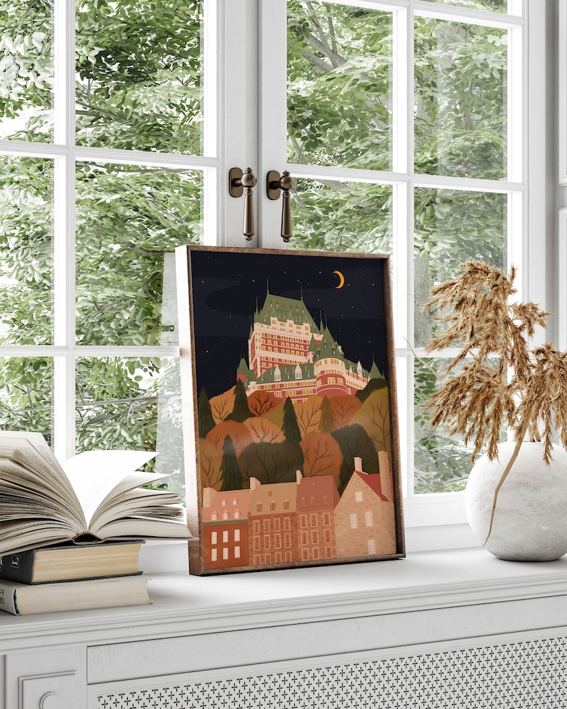 May include: A framed illustration of a cityscape at night with a large building on a hill, surrounded by trees and smaller buildings. The sky is dark blue with a crescent moon and stars. The buildings are a mix of red, brown, and white.