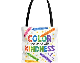 Könnte beinhalten: Weiße Tragetasche mit schwarzen Griffen. Das Design zeigt den Text "COLOR the world with KINDNESS" in bunten Buchstaben, mit Buntstiftillustrationen und Sätzen wie "You are loved" und "You are smart."