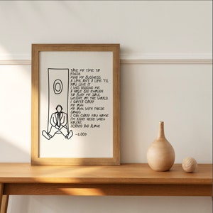 May include: Black and white illustration of a person sitting on a ledge with a circle behind them. The illustration is accompanied by a handwritten lyric from a song. The lyrics read: "Take my time to finish mind my business a life ain't a life 'til you live it I was digging me a hole big enough to bury my soul weight of the world. I gotta carry my own my own with these songs I can carry you home I'm right here when you're scared and alone -2.009"