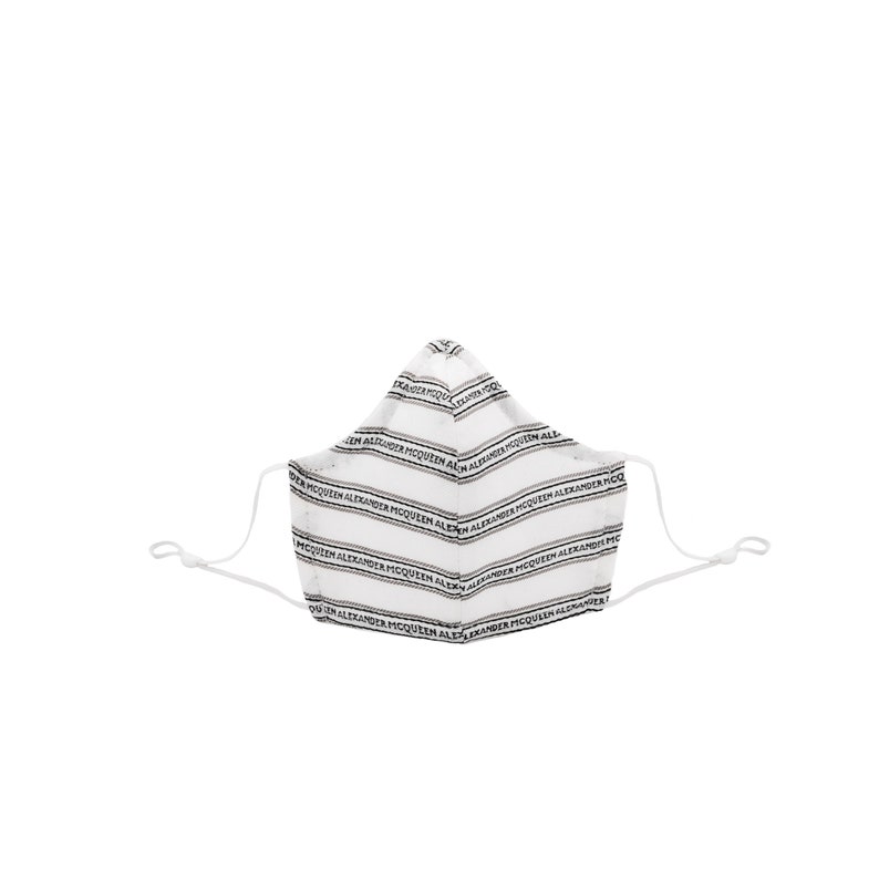 May include: White face mask with black stripes and the text "ALEXANDER McQUEEN" repeated across the fabric.