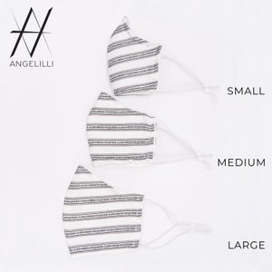 May include: Three white face masks with black stripes and the text "Alexander McQueen" repeated across the fabric. The masks are labelled "Small", "Medium", and "Large".