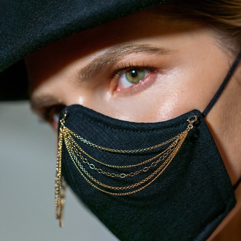Pu&ograve; includere: Una maschera facciale nera con un dettaglio a catena dorata. La maschera &egrave; realizzata in un tessuto morbido e traspirante e ha una vestibilit&agrave; comoda.