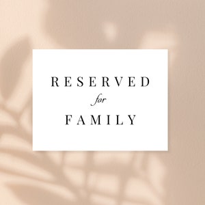 Könnte beinhalten: Weiße Karte mit schwarzem Text, der "RESERVIERT für FAMILIE" lautet.