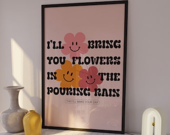 May include: A pink and black framed poster with the text "I'll bring you flowers in the pouring rain. They'll make your day." with three yellow and pink smiley face flowers.