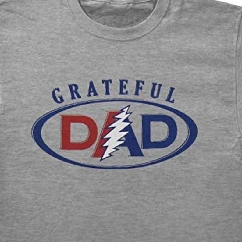 May include: Gray t-shirt with a blue and red oval graphic that says "GRATEFUL DAD" with a lightning bolt design inside the oval.