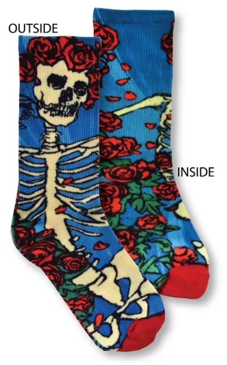 K&ouml;nnte beinhalten: Ein Paar bunte Socken mit einem Skelett- und Rosenmuster. Die Socken sind blau, rot, gr&uuml;n und gelb. Die W&ouml;rter "AUSSEN" und "INNEN" sind auf den Socken aufgedruckt.