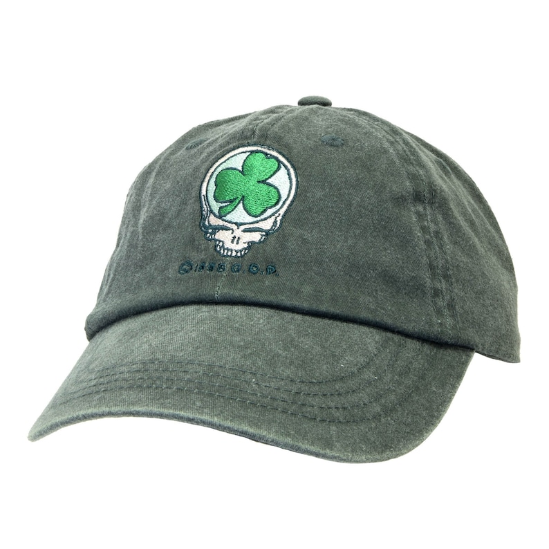 Puede incluir: Una gorra de b&eacute;isbol verde oscuro con un tr&eacute;bol verde dentro de un gr&aacute;fico de calavera sonriente. El texto "Grateful Dead" est&aacute; bordado debajo del gr&aacute;fico.