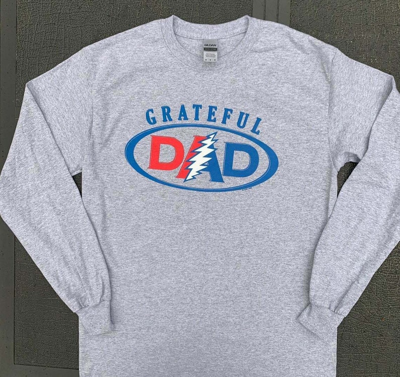 May include: Gray long-sleeve t-shirt with a blue and red oval graphic that says "GRATEFUL DAD" with a lightning bolt design inside the oval.