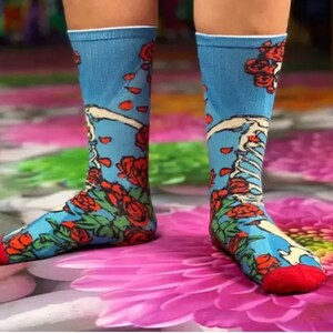 K&ouml;nnte beinhalten: Ein Paar blaue Socken mit einem roten, wei&szlig;en und gr&uuml;nen Blumenmuster. Die Socken haben ein Skelett-Design und sind aus einem weichen, bequemen Material gefertigt.