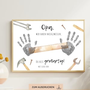 Könnte beinhalten: Gerahmter Druck mit dem deutschen Text "Opa, Wir haben nachgemessen, Du bist großartig!" mit Handabdrücken, einem Lineal und Werkzeugen. Der Druck hat einen hellen Holzrahmen und den Text "ZUM AUSDRUCKEN".