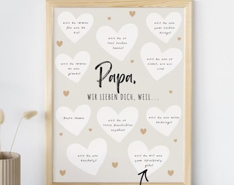 May include: A framed print with a light beige background and a wooden frame. The print features the word "Papa" in a handwritten font, surrounded by white heart shapes and text in German. The bottom of the print has the text "ZUM SELBST AUSFÜLLEN".